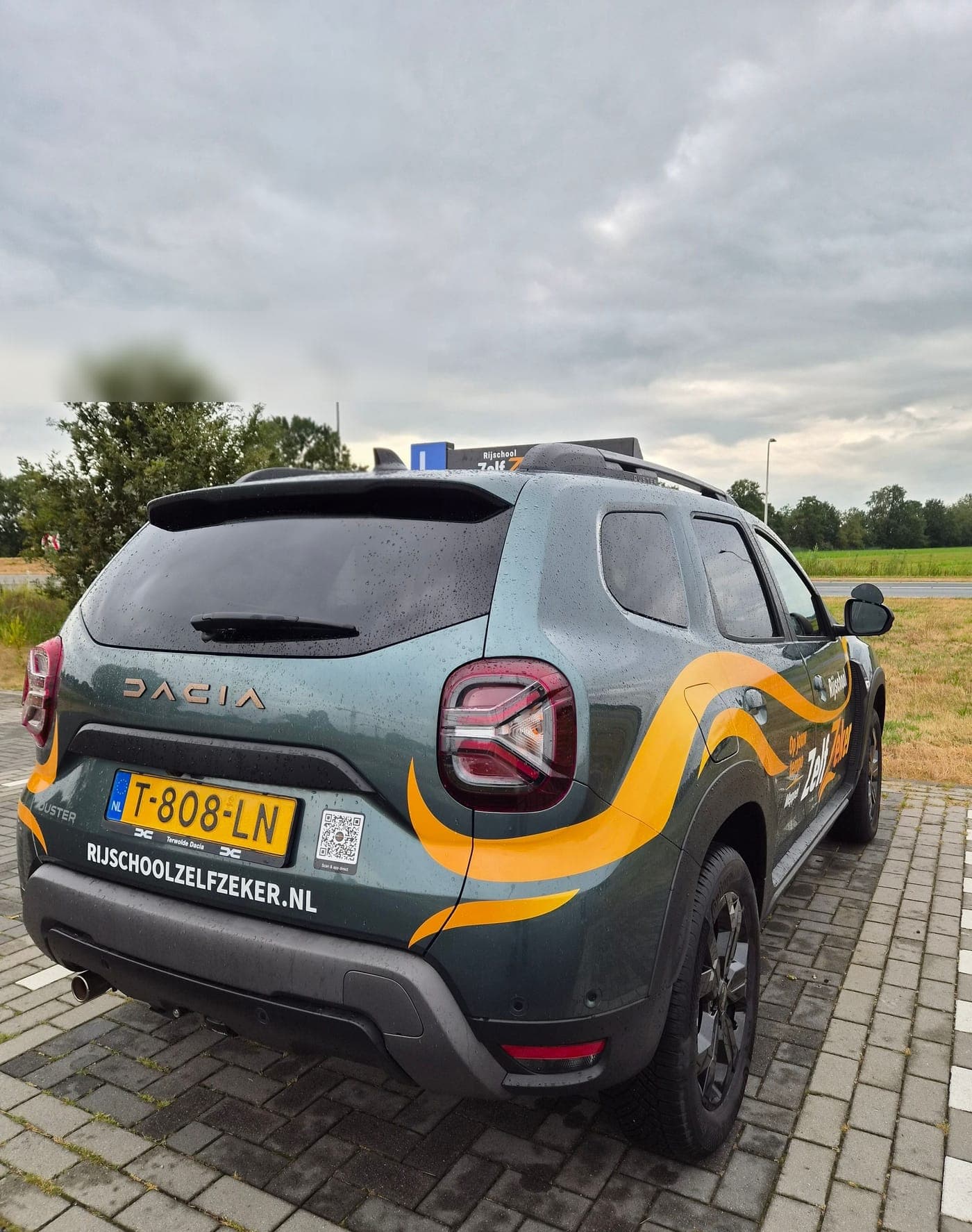 De achterkant van de ZelfZeker-lesauto met rijschoolzelfzeker.nl